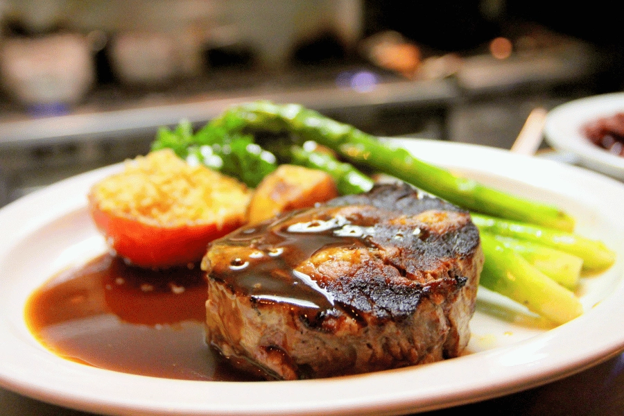 delicious steak on a plate served alongside asparagus 